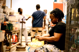 Female business owner in African marketplace selling goods