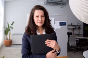 A confident woman in professional attire in a modern hospital or office setting
