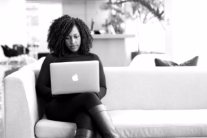 African woman entrepreneur working at a laptop in a bright modern coworking space