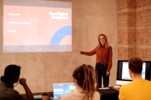 Women professionals at a technology training session with laptops and presentation screen