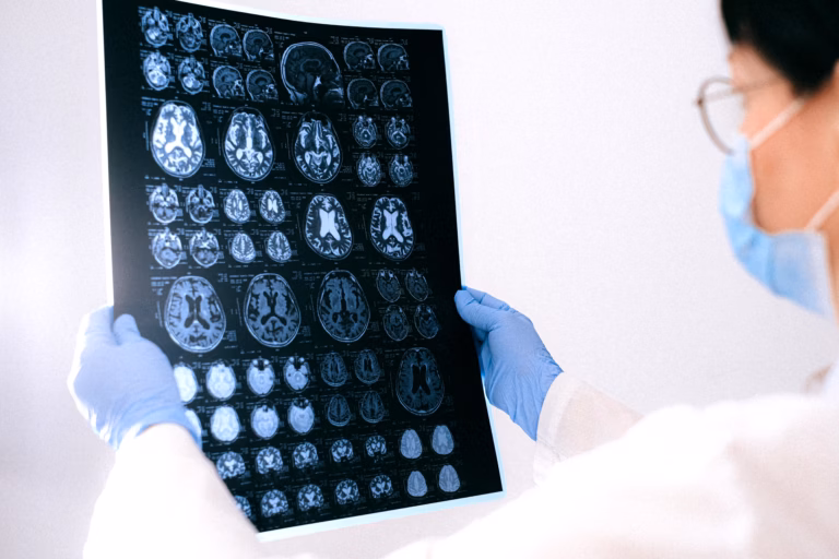 A physician reviews a brain scan on a monitor in a hospital setting