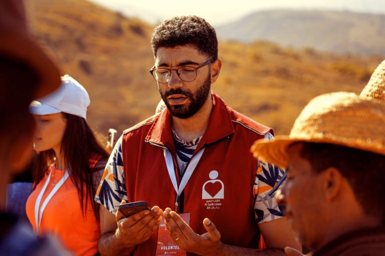 Aid worker consulting with a local woman about program needs in a field setting