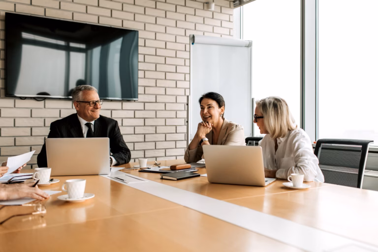 Women executives seated around a boardroom table during a formal meeting