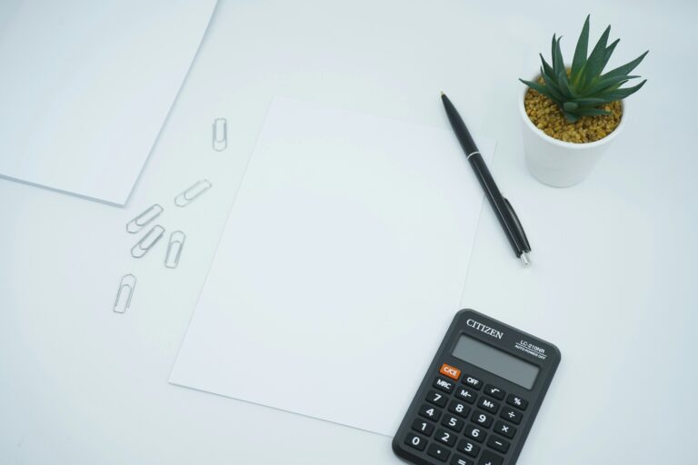 Hands reviewing financial documents with a calculator on a desk