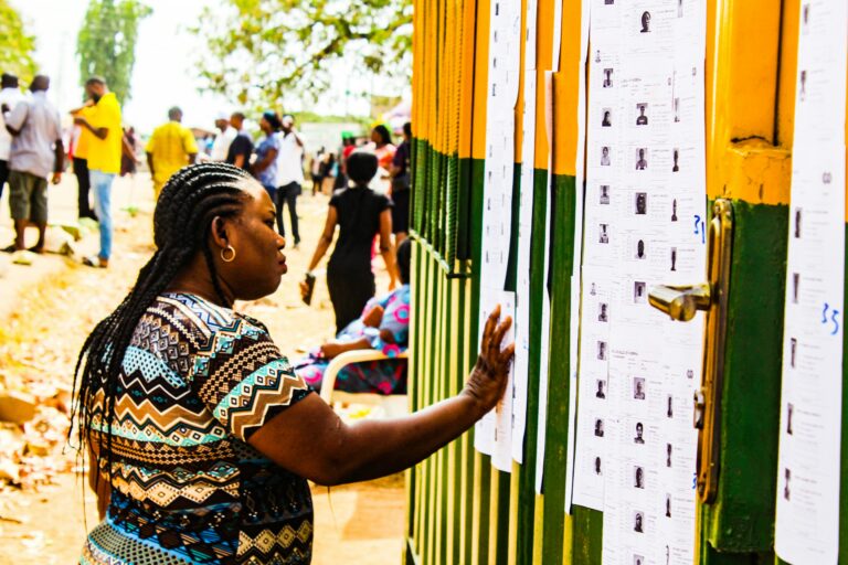 Two Nigerian women business owners review financial paperwork together at a small shop