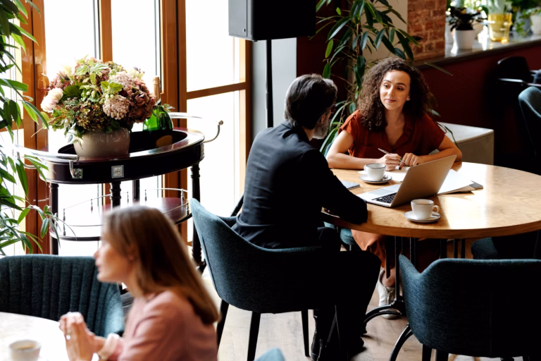 ACORNS Program Boosts Rural Female Entrepreneurship With New Jobs and Turnover Growth 2 A woman discusses business on a laptop in a bright cafe setting