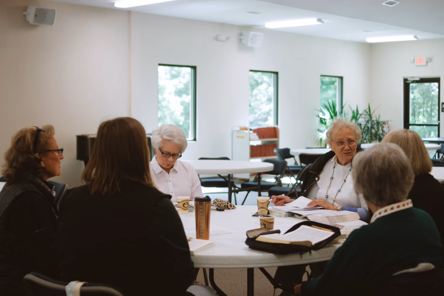 A diverse group of women meeting in a modern, collaborative workspace