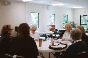 A diverse group of women meeting in a modern, collaborative workspace