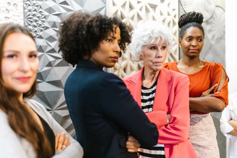 A diverse group of women standing confidently in an office environment, showcasing empowerment and leadership