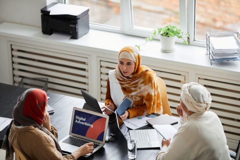 New SPBD Fiji Leader Prioritizes Digital Growth for Women Entrepreneurs 1 Three businesswomen in hijabs discussing digital advertising at an office table