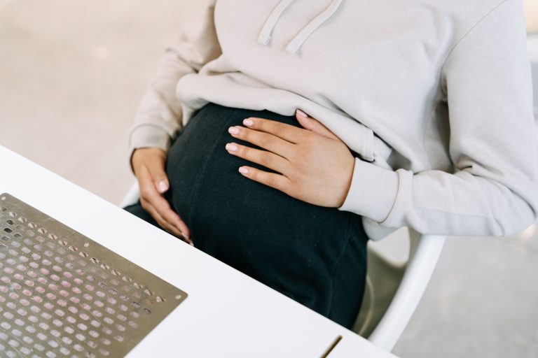 Rural Ireland Backs Abortion Leave Protections in New Survey 1 Close-up of a pregnant woman sitting and touching her belly indoors