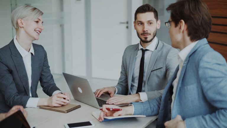 Why Experienced Women Are Leaving Ireland's Workforce Early 2 Business professionals in a meeting with laptops and notebooks, discussing strategy