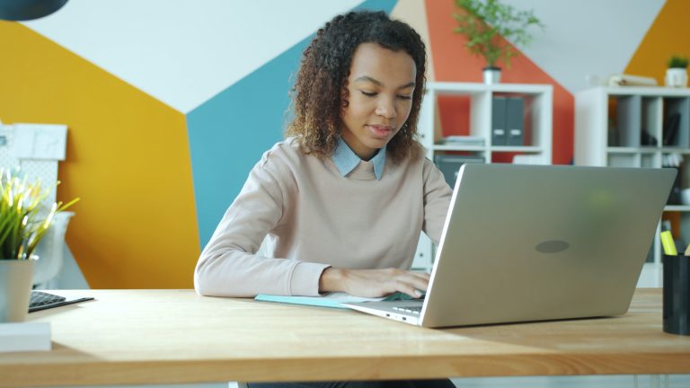 Female Entrepreneurs in MENA Face a Persistent Funding Gap 1 Young woman focused on work at a modern office, using laptop. Bright and vibrant setting