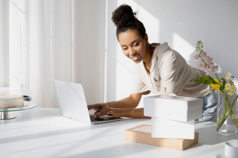 Woman business owner working on a laptop in her shop