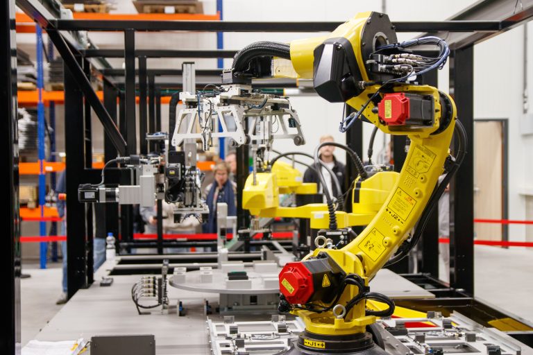 Twenty Female Founders Featured In Expanded Swiss AI Report 2 A yellow industrial robotic arm with a gripper, an illustrative stock scene
