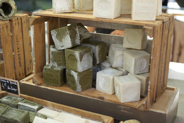 Soap blocks displayed in wooden boxes at a market, an illustrative stock photograph
