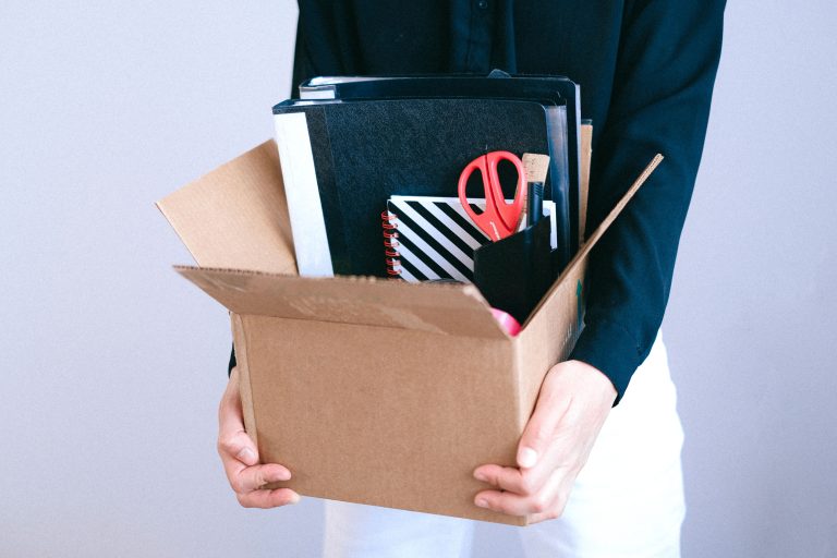 Laid-Off Workers Back: 39% Of Women Would Return, Survey Finds 1 Person holding a box of office belongings