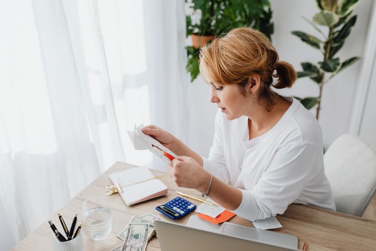 Women Entrepreneurs Access Finance: CONAF Plans New Barometer 2 Woman checking receipts beside a calculator