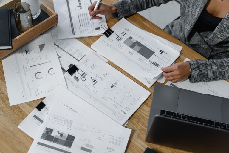 Women Entrepreneurs Access Finance: CONAF Plans New Barometer 1 Person reviewing financial reports beside a laptop