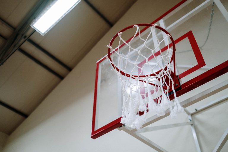 Red basketball rim and net inside a gym