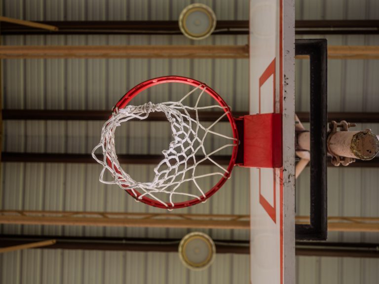 Basketball hoop and backboard viewed from below in an indoor gym