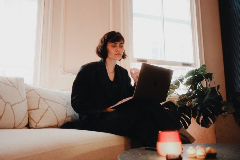 Woman Found Dead After Workplace Injury Claim Stress 1 Woman in suit using laptop on sofa in bright room, modern lifestyle