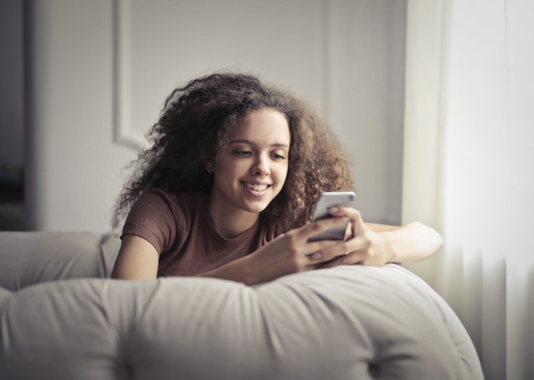 Nigeria’s Digital Economy Leaves Women Facing Access Barriers 1 Woman using a smartphone while reclining indoors